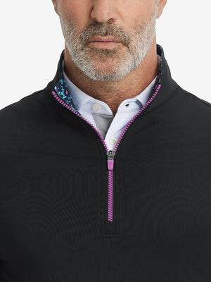 Close-up from nose to chest, showing collar and zipper detail of the black golf pullover.