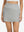 Front lower body shot of model wearing glacier grey high waist built-in short a-line golf skirt with 5 pockets