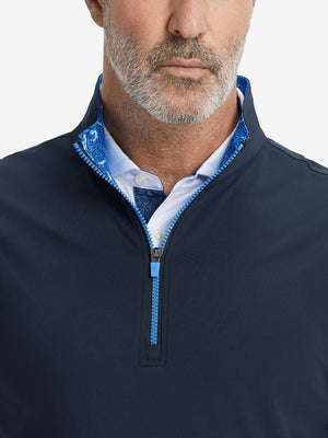 Close-up from nose to chest, showing collar detail and zipper of the navy golf vest.
