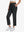 Front lower-body view of model with right hand in pocket wearing BLACK Women's 7/8 Ankle Golf Track Pants.
