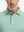 Close-up from nose to chest, showing collar and fabric pattern detail of the green plant polo shirt.