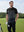 Model in blackdark grey premium performance polo holding a golf club outdoors, half-body shot
