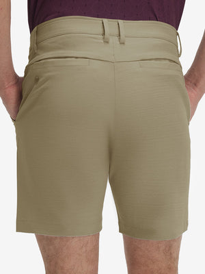Back lower body shot of model wearing khaki flat front hybrid golf shorts
