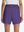 Back lower body shot of model wearing dark purple women's gym golf shorts with liner pocket