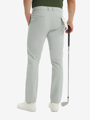 Rear lower-body: model in light grey stretch quick dry casual golf pants with 4 pockets holding golf club in right hand.