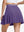 Back lower body shot of model wearing dark purple women's moisture-wicking athletic tennis skirts