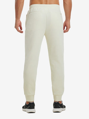 Back lower body view showing beige soft sweatpants with 4 zipper pockets