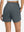 Back lower body shot of model wearing dark grey women's high waist 2 in 1 quick dry shorts with 7 pockets