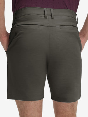 Back lower body shot of model wearing tea brown flat front hybrid golf shorts