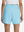 Back lower body shot of model wearing lake green women's gym golf shorts with liner pocket