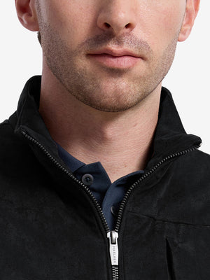 Front view from nose to chest of model wearing black classic micro suede leather puffer vest