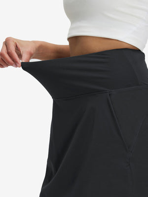 Detail view of elastic waistband on black women's stretch a-line golf skort with 7 pockets