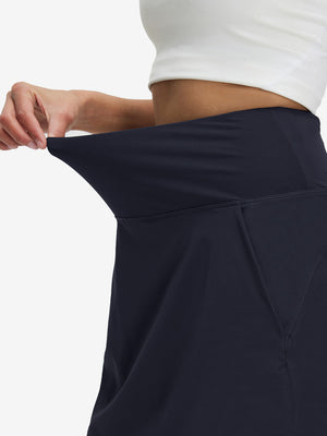 Detail view of elastic waistband on navy blue women's stretch a-line golf skort with 7 pockets