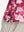 Detail view of hem on red splatter women's sleeveless v-neck print golf shirts