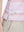 Detail view of hem on pink purple stripes women's sleeveless v-neck print golf shirts