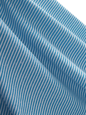 Close-up texture of blue white women's q-zip pin striped texture golf shirts fabric showing pin striped weave detail.
