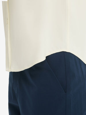 Detail view of hem on cream cool print plain button up shirts