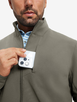 Close detail of hand in chest pocket of water-resistant zip up golf jacket in dark khaki.