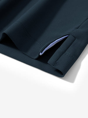 Detail view of hem on navy dry fit waffle textured collared golf shirts