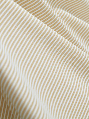 Close-up texture of beige white comfy breathable pin-stripe texture golf polos fabric showing weave detail.