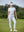 Woman wearing Women's Ultra-stretch Quick Dry Sweatpants with Ankle Zips in white, holding golf club on course