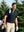 Front upper body angled shot of male model wearing navy ultra-comfort slim fit roma knit polo shirt with golf bag on back