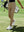 Model on outdoor golf course wearing light khaki women's lighweight athletic sweatpants
